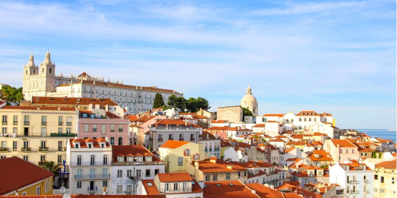 A scenic view over Lisbon's historic Alfama district showcasing traditional architecture under a clear sky.