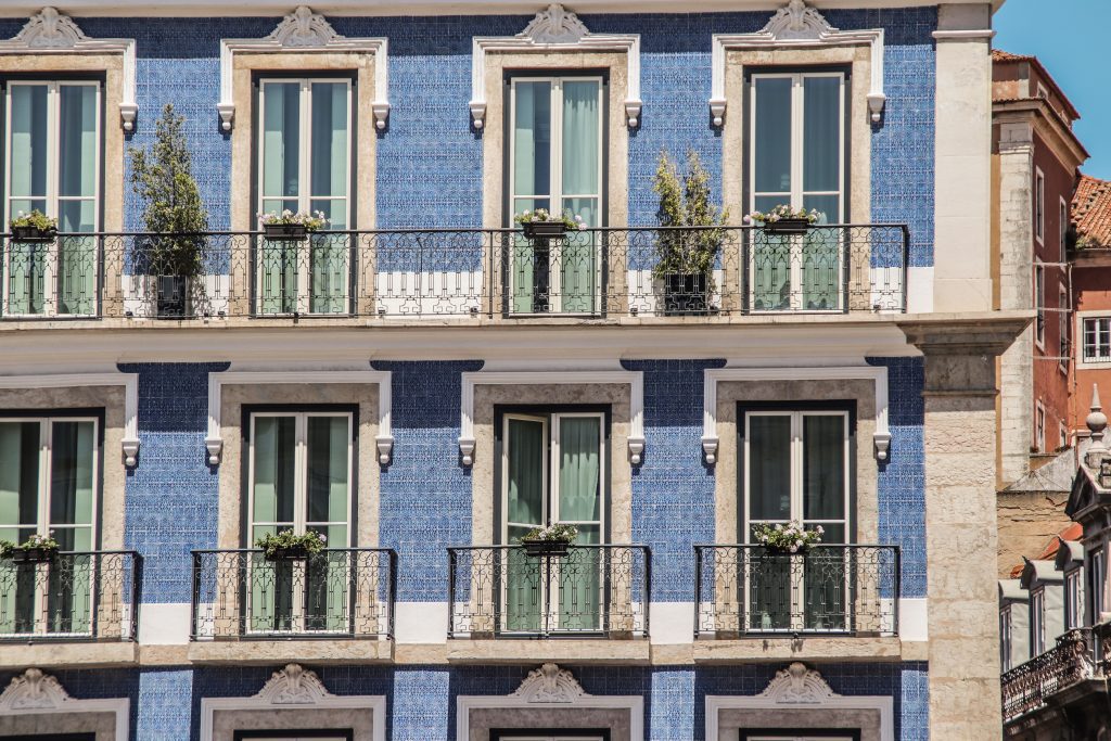 Elegant building facade with traditional blue tiles and balconies in Lisbon, Portugal.