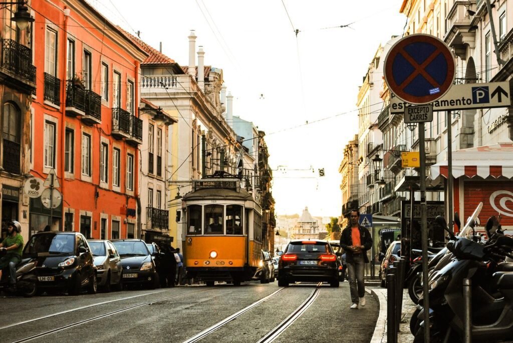 Quaint street scene featuring a historic tram amidst bustling urban life in Porto, Portugal.